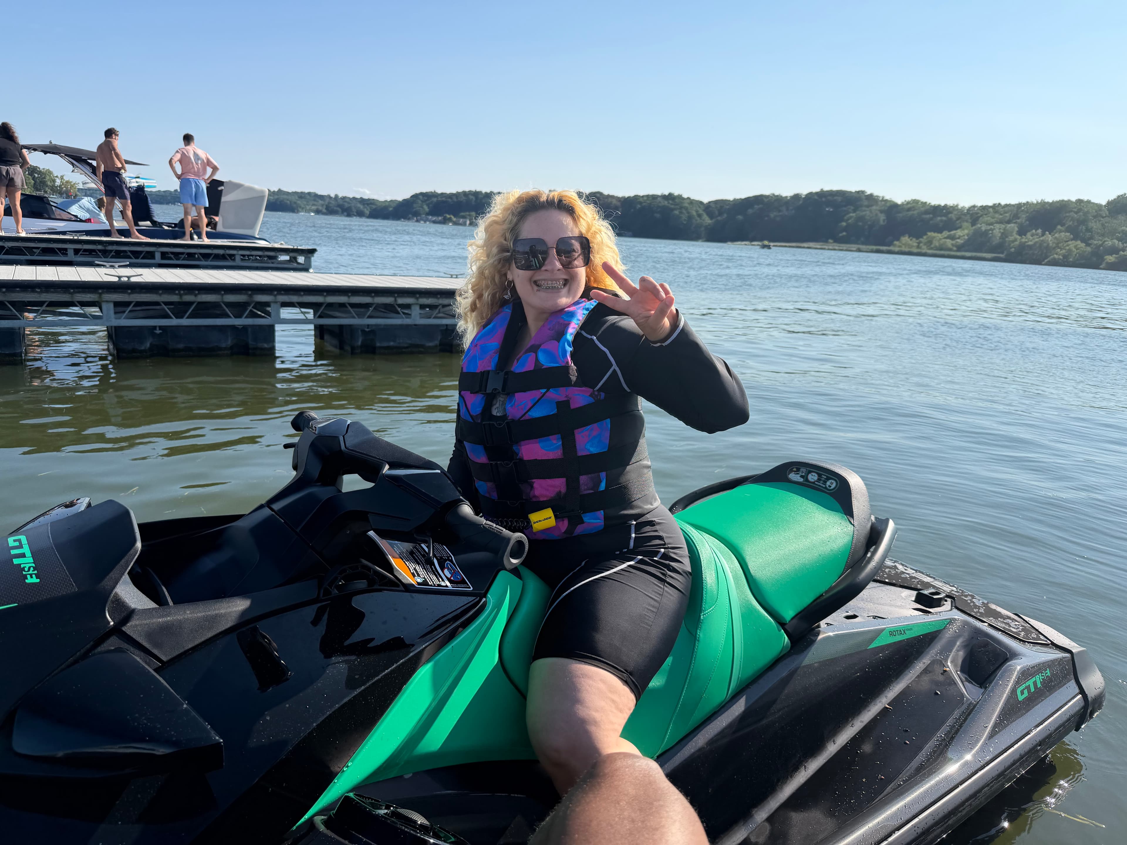 Smiling rider sitting on a green JetSki Vibes jet ski
